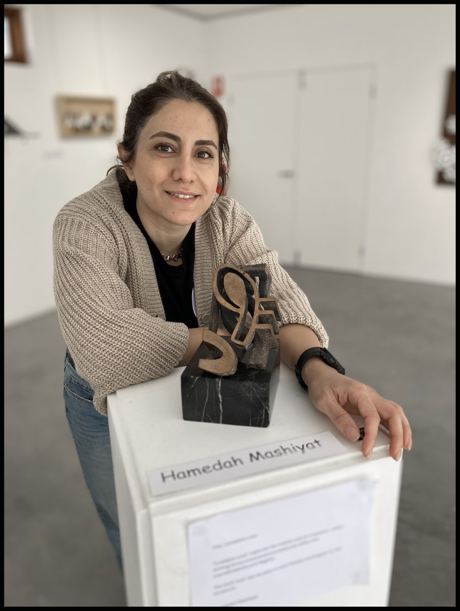 A woman standing next to a sculpture