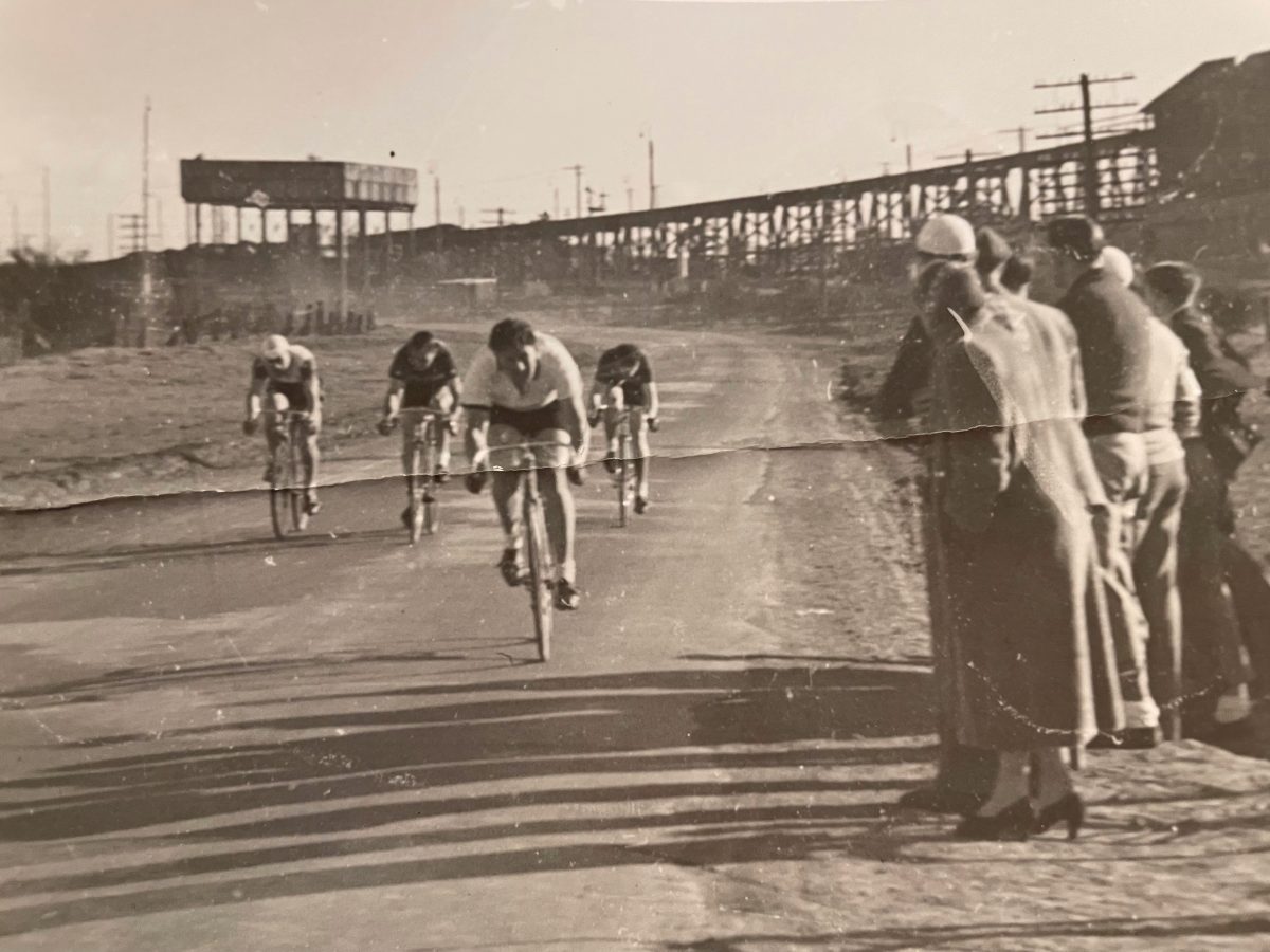 Reg leads a bunch of cyclists along the Braidwood Road, with the ramp up to the railway coal loader in the background.