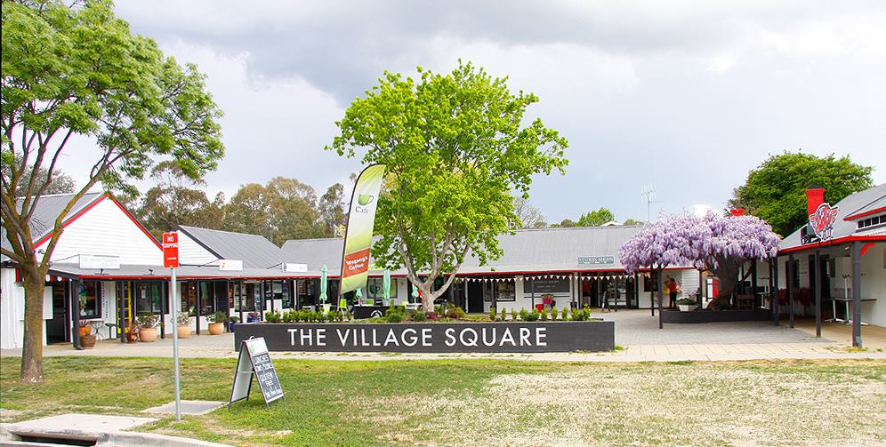 Buildings arranged on the outside of a large courtyard with a sign