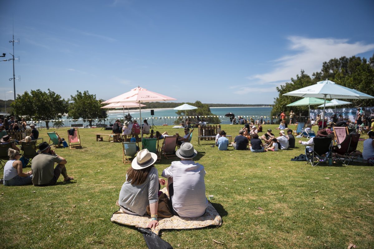 people sitting on a coastal lawn