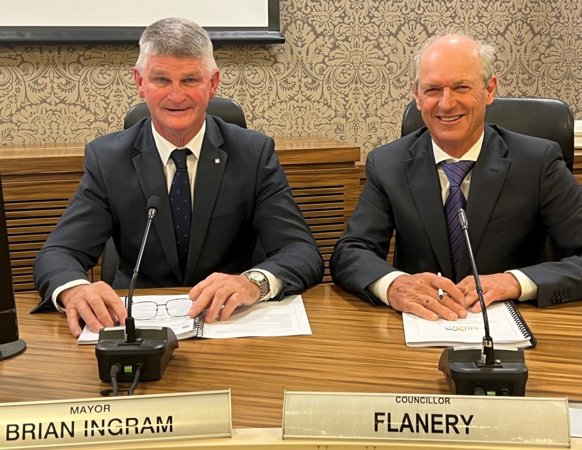 two suited men sitting at a table 