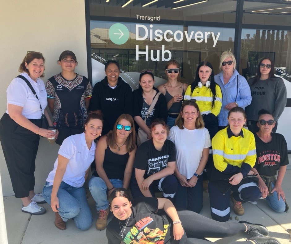 15 women in front of a window that says Discovery Hub