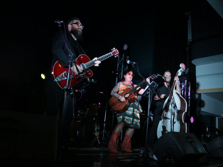 Three people arranged on stage