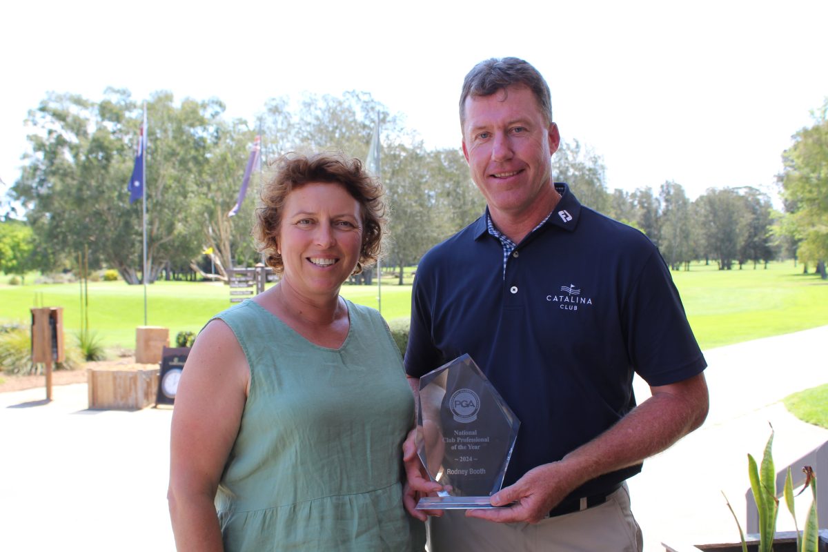 A woman and a man standing next to each other, with the man holding a trophy