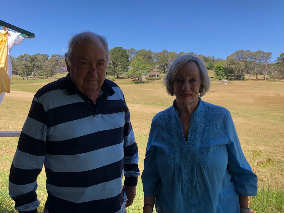 elderly couple with open green space behind them