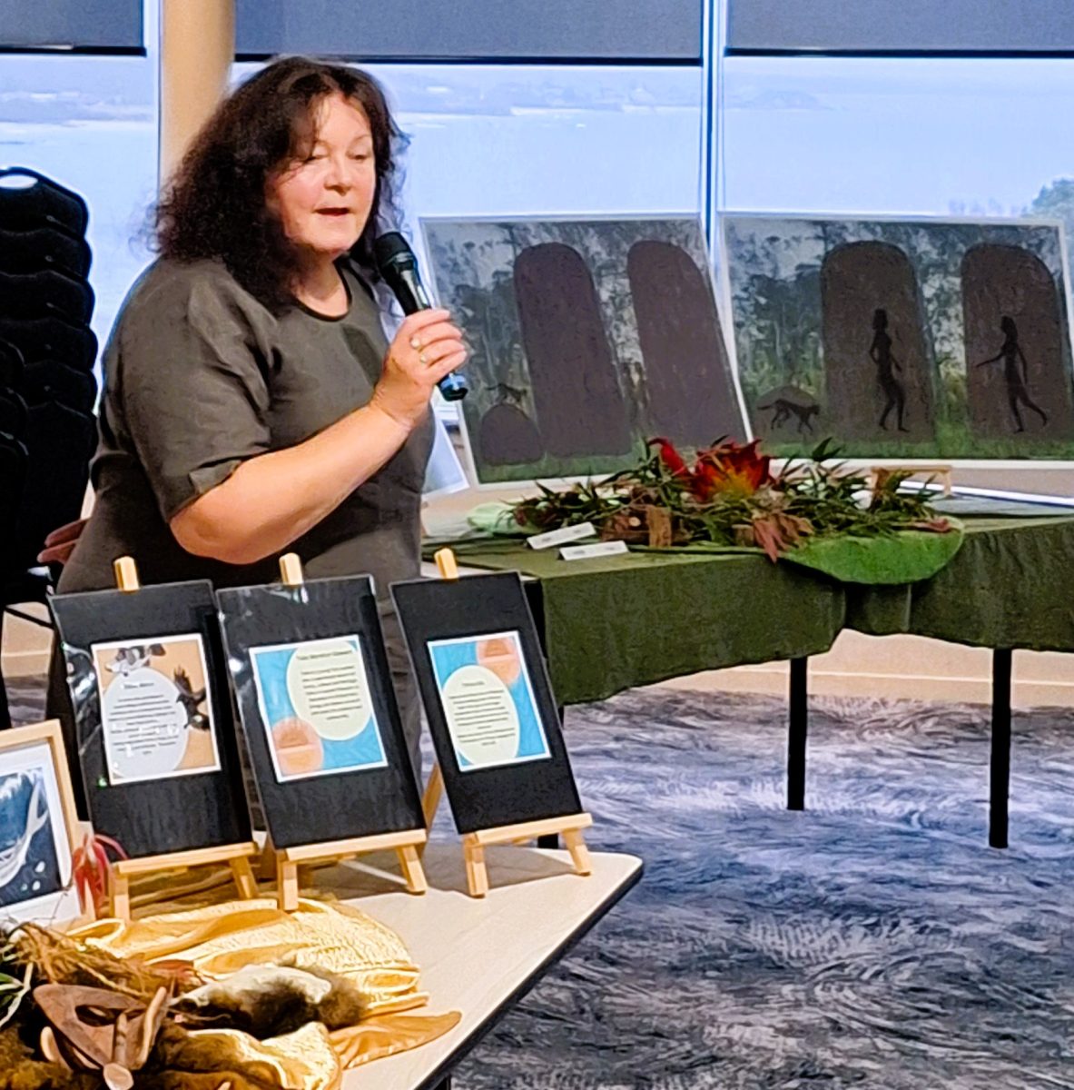 A woman speaking into a microphone while standing at a display