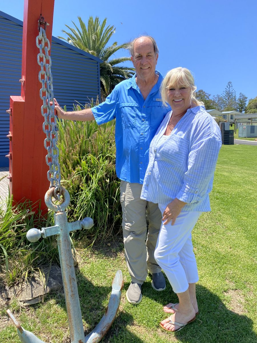 A man and a woman standing next to an anchor