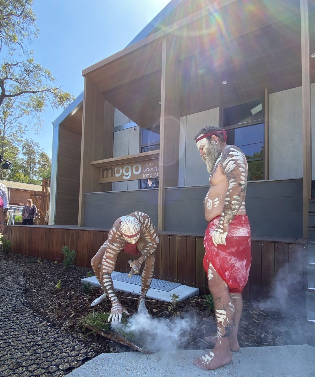 Two Aboriginal men perform a smoking ceremony