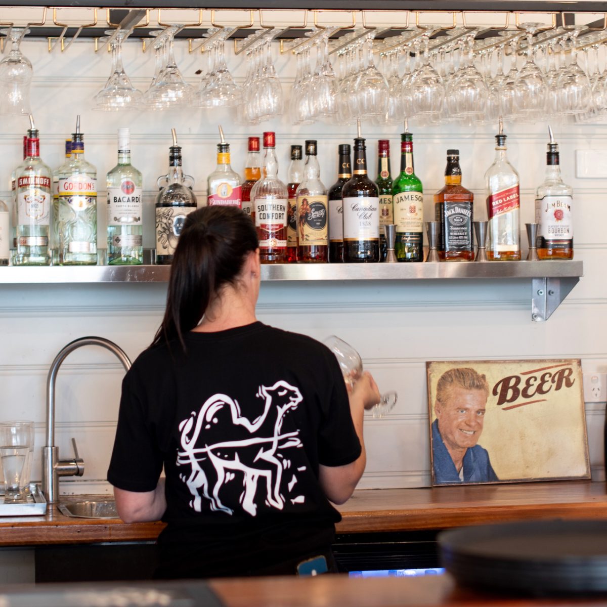 woman cleaning glasses at a bar