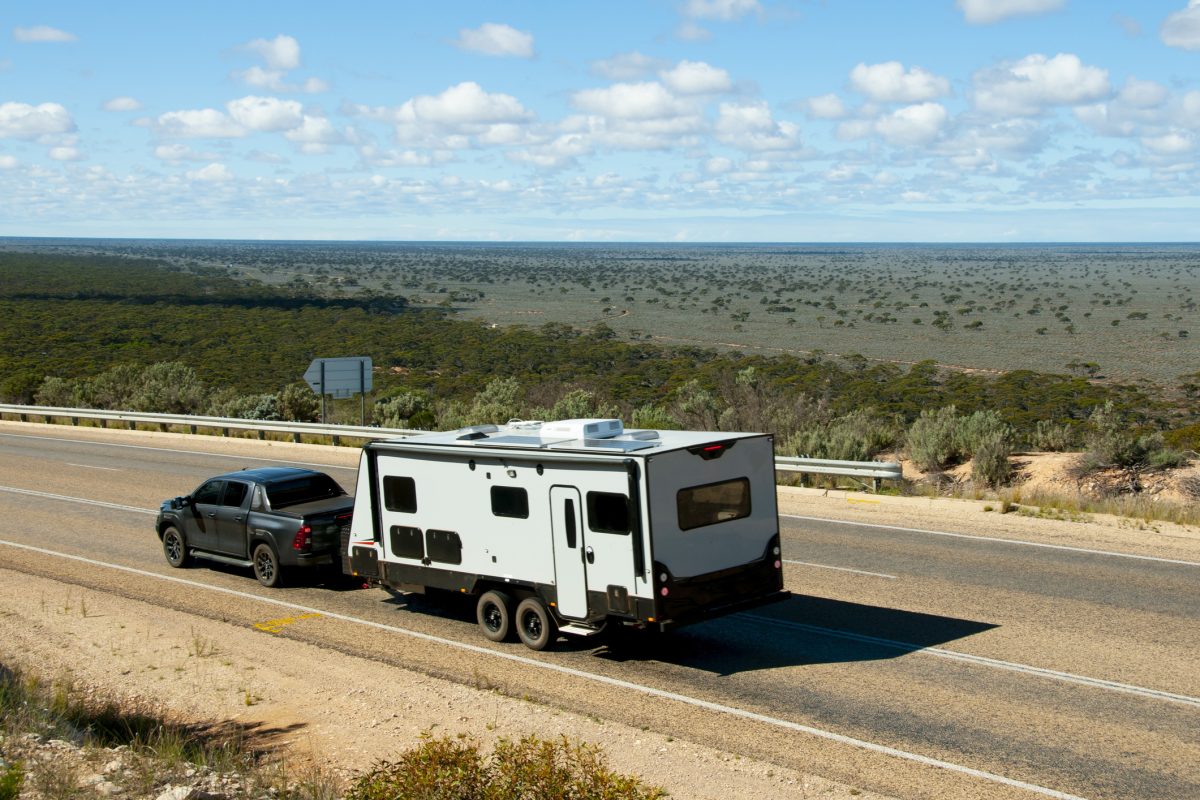 A car towing a caravan along a road in the country