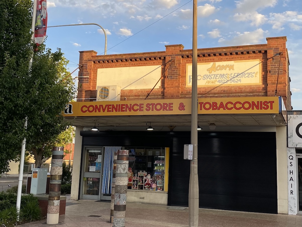 Shutters are partially drawn on this convenience and tobacconist shop in Auburn Street. 