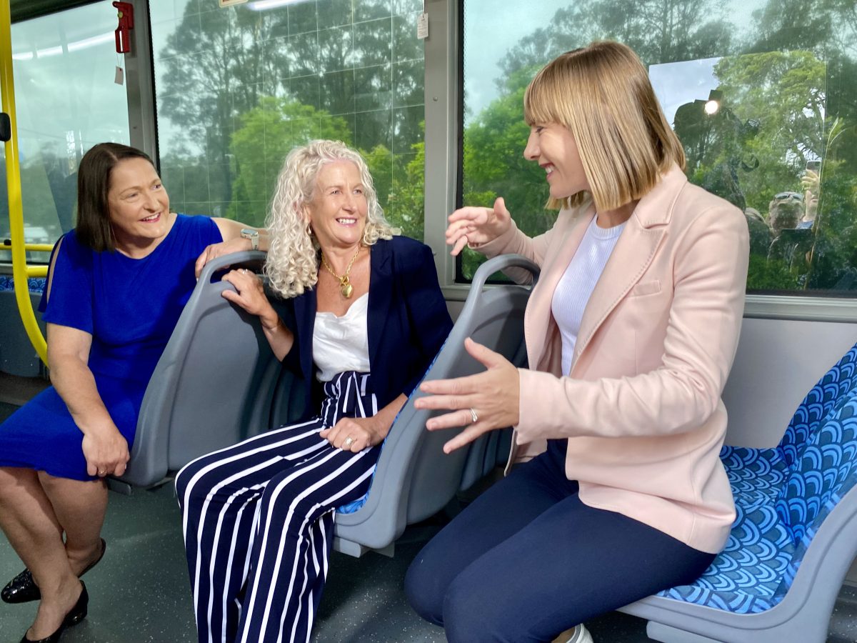 Three women talking while sitting in a bus