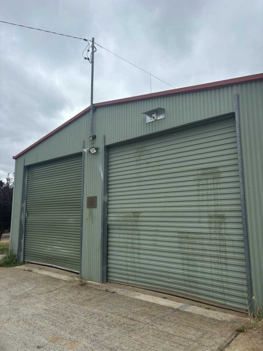 A green shed with both roller doors shut