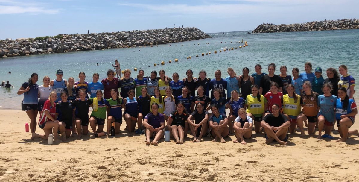 The 50 members of the Canberra Raiders' 2025 Under 17 and Under 19 teams after a training and mentoring session at Narooma's Bar Beach on Saturday 25 January. 