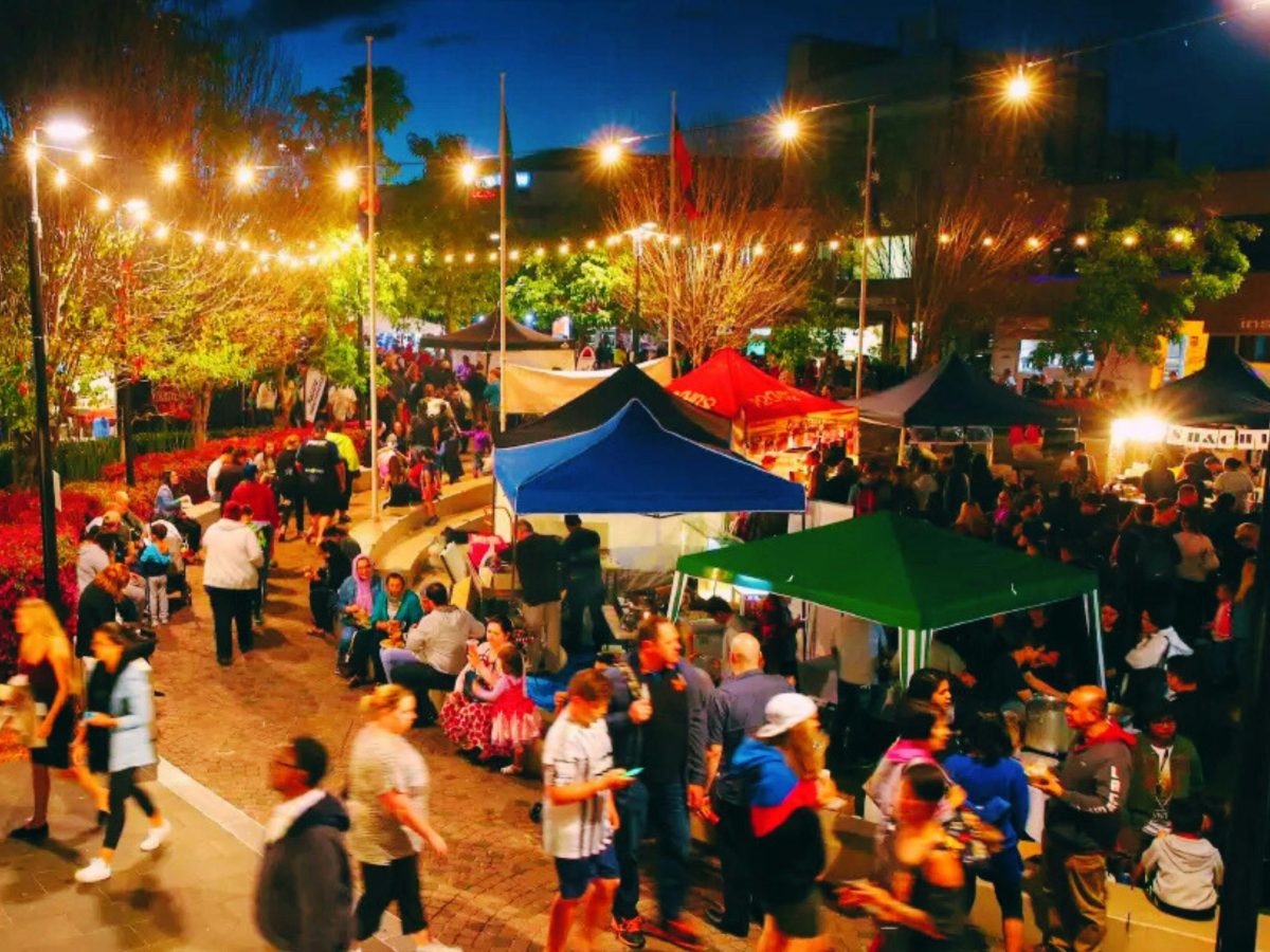 A summer market with lots of multicoloured tents and lights on strings