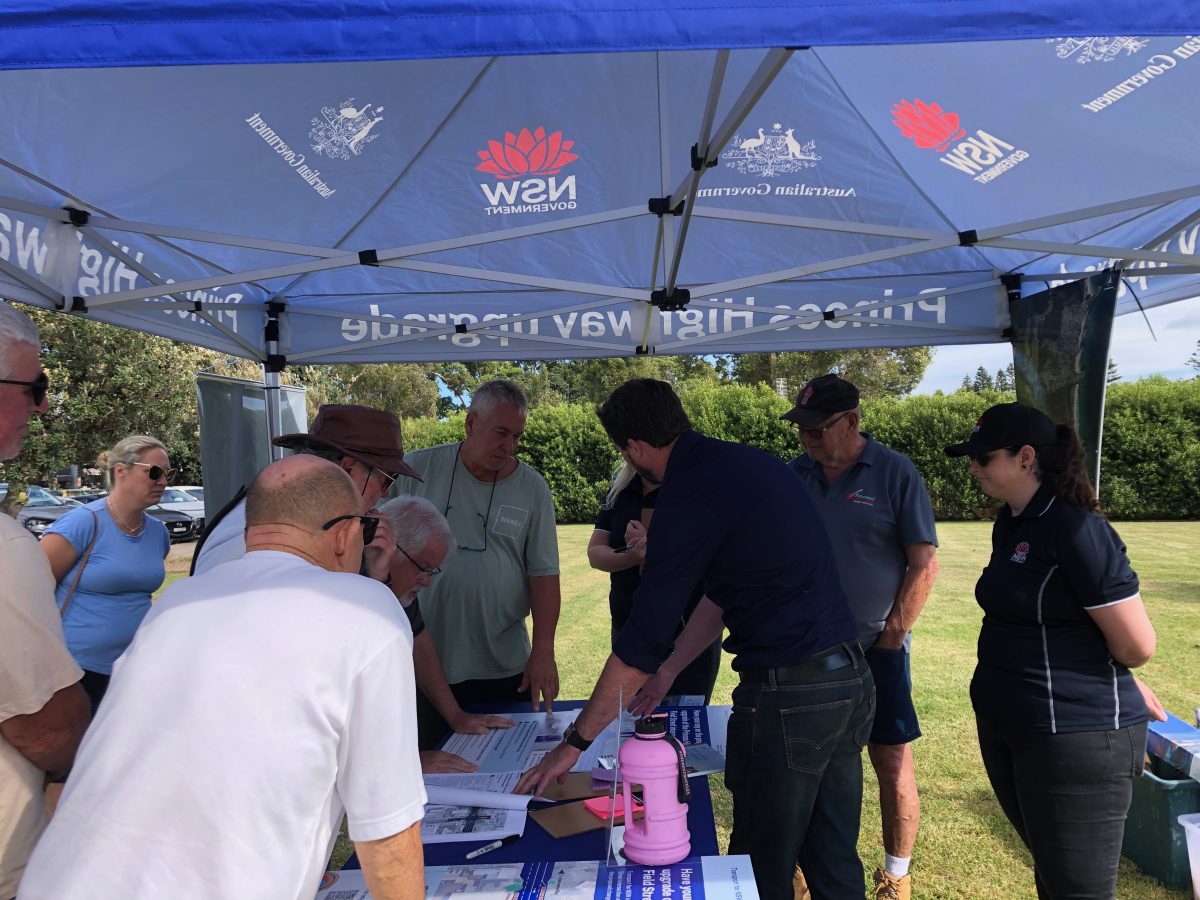 people looking at leaflets under an information tent