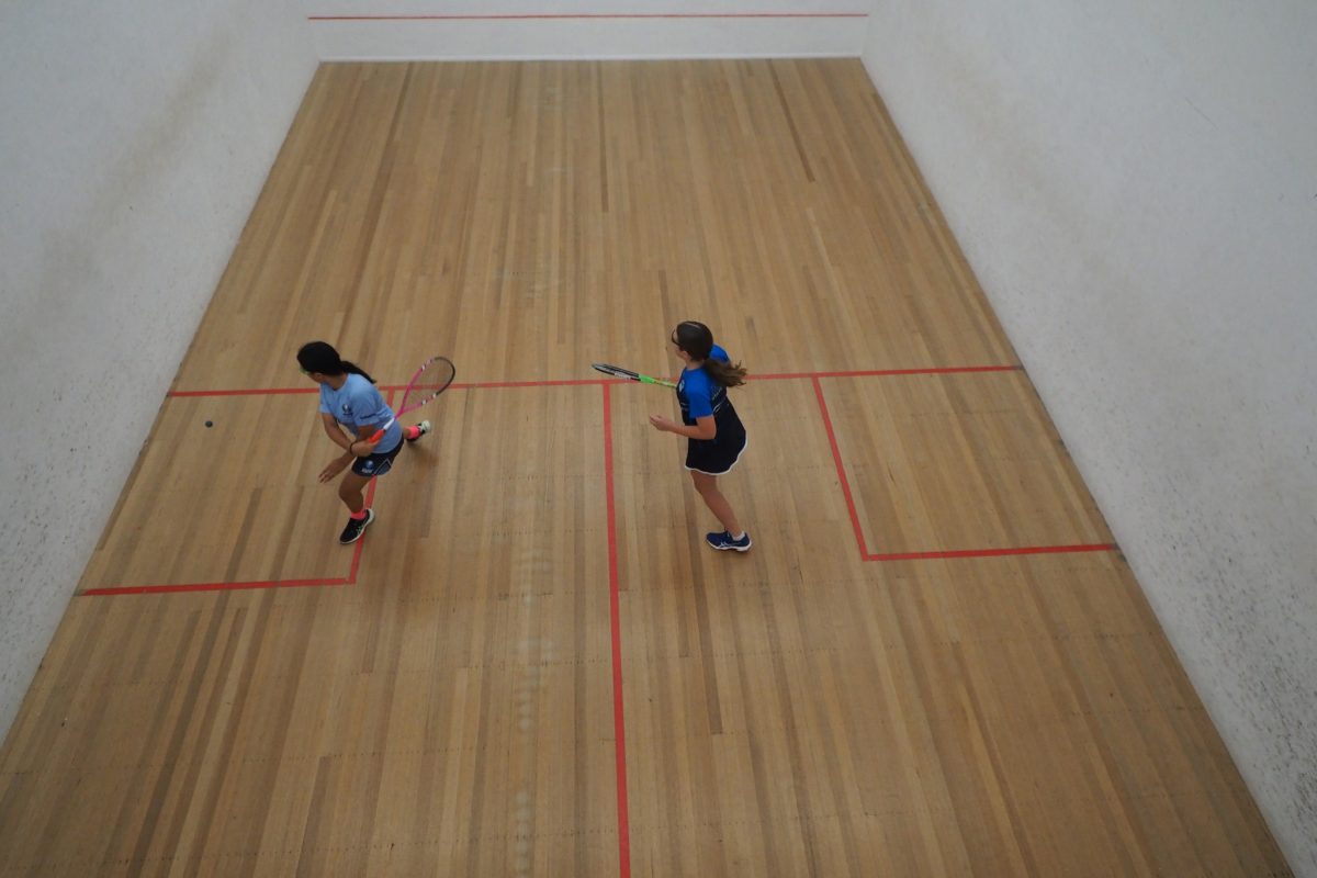 Two young girls playing squash