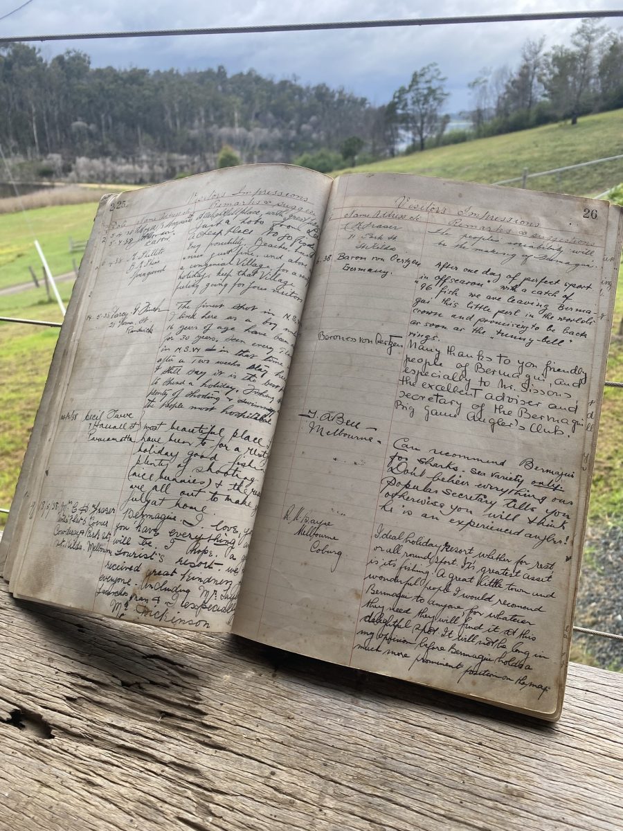 An old guest book open and propped upright