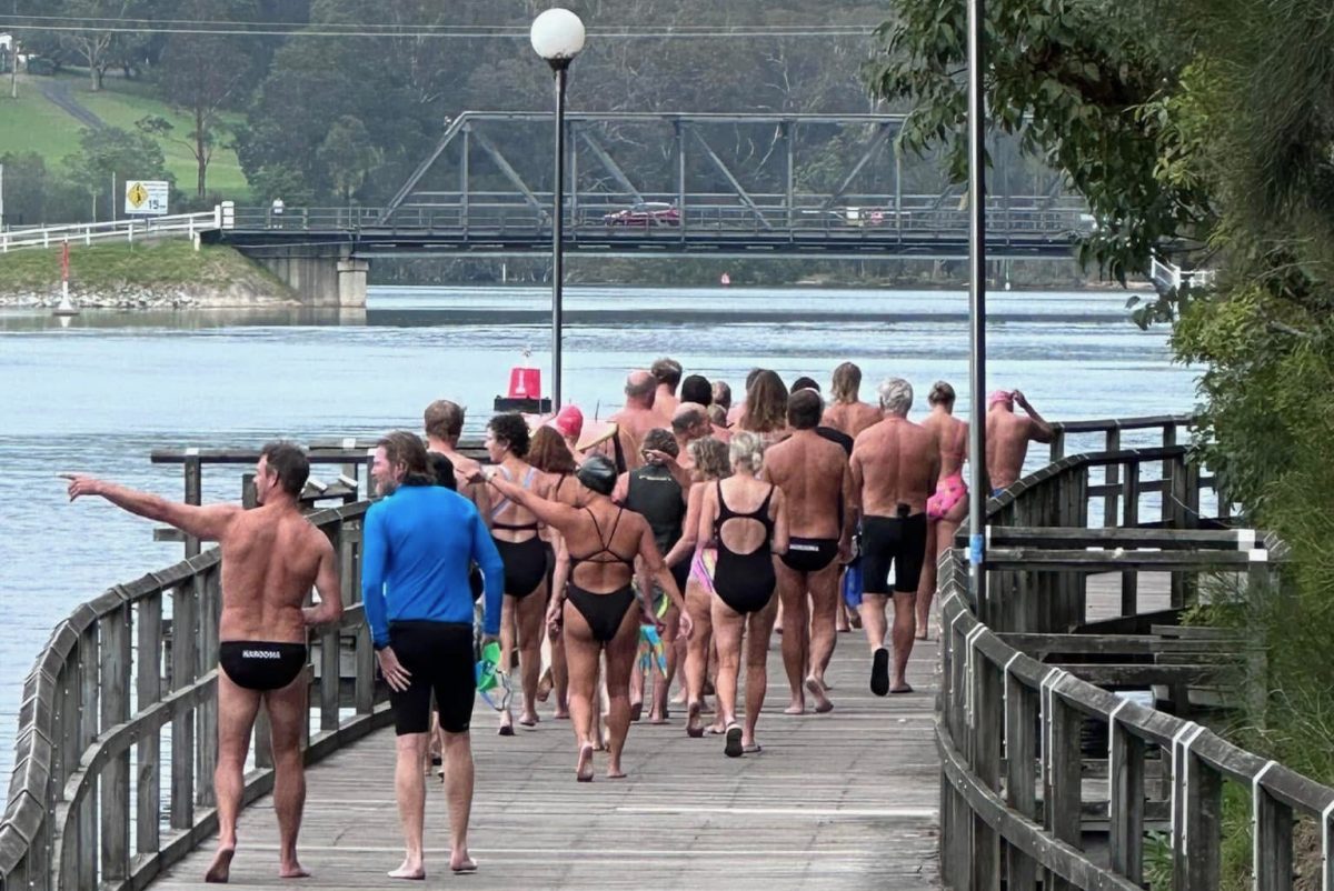 a group of people heading off for an ocean swim