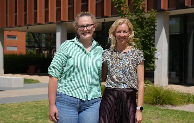 two women linking arms and smiling