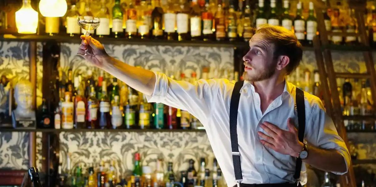 man at a bar holding a wine glass