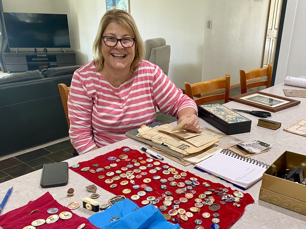 Diane Bush with some of her nanna’s keepsakes which include newspaper clippings, family photos, numerous badges and a peep view box resembling a tiny camera through which the viewer can see black and white landmarks of Melbourne to coincide with the 1956 Olympic Games.