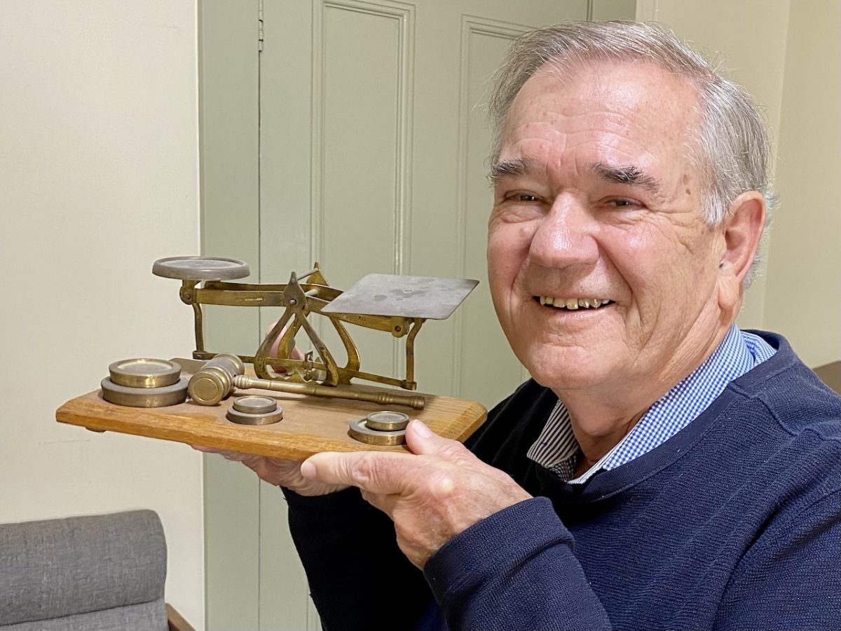a man holding an old set of scales