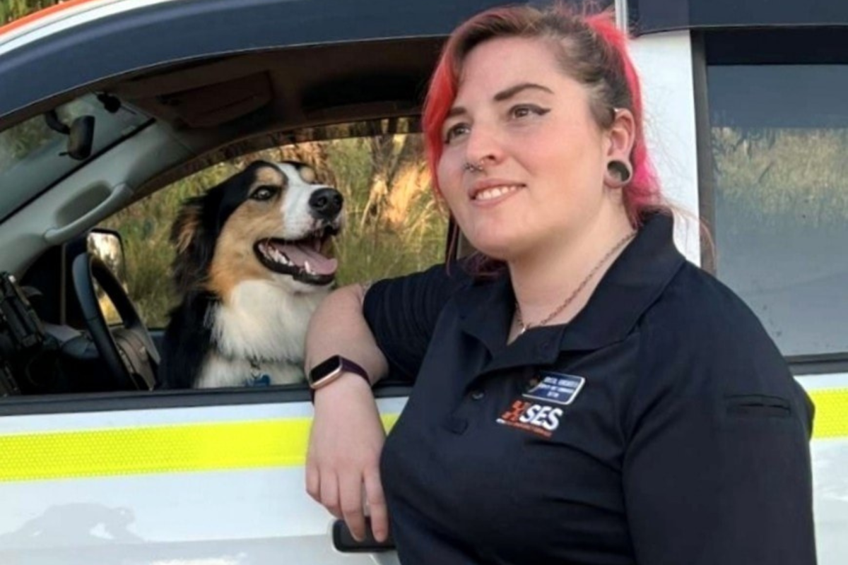 Woman stands in front of a car with a dog in it
