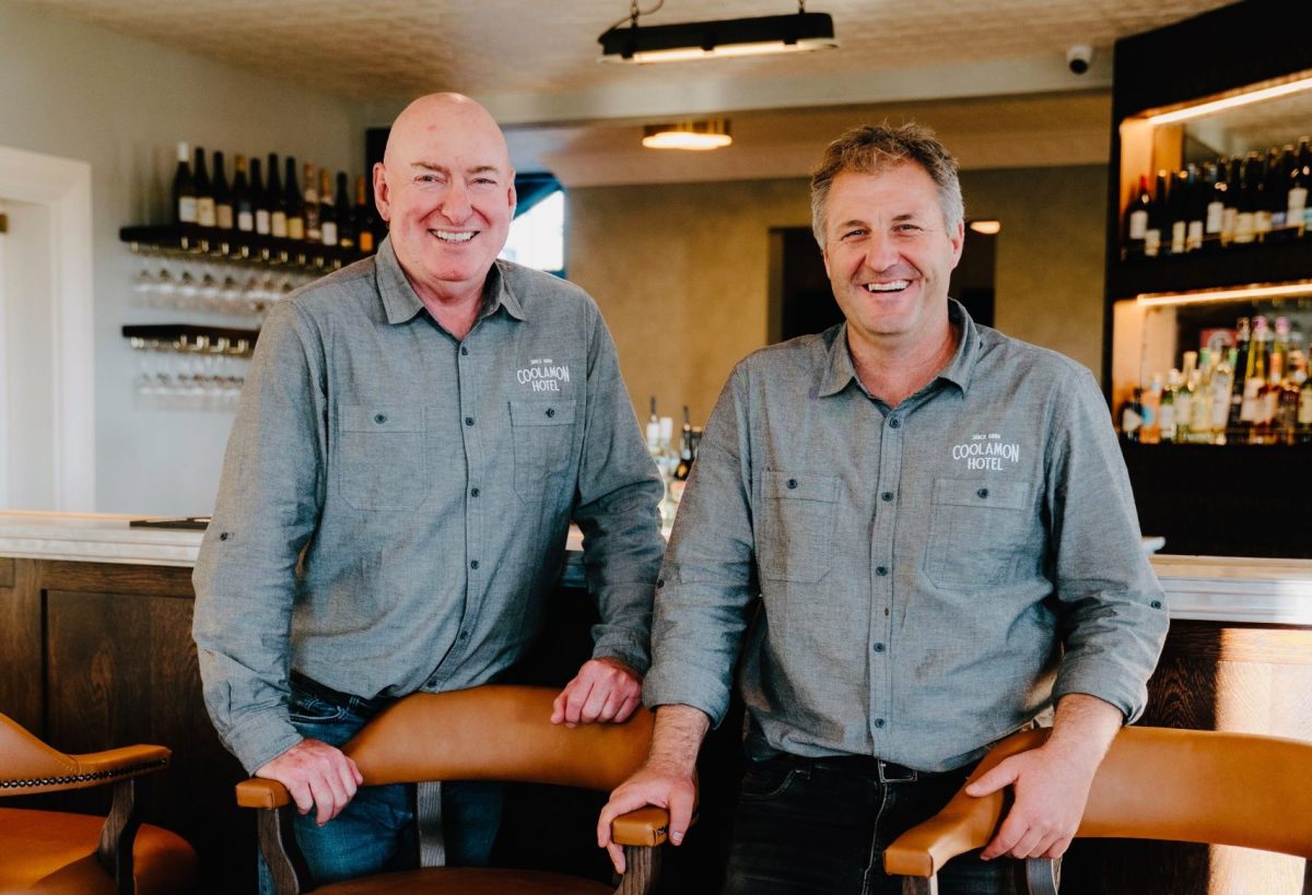 two men smiling in a bar