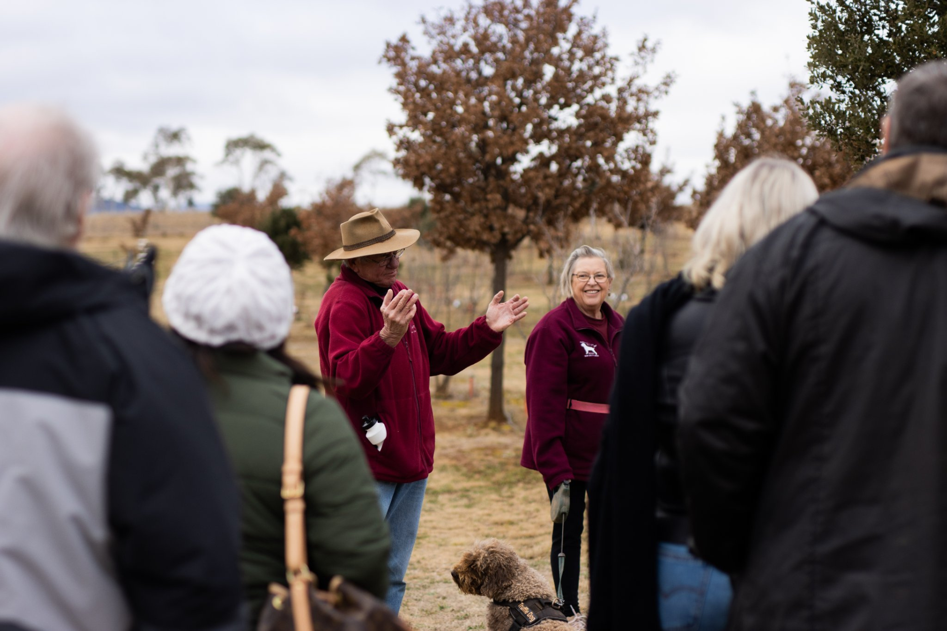 Man and woman talking to group outdoors.