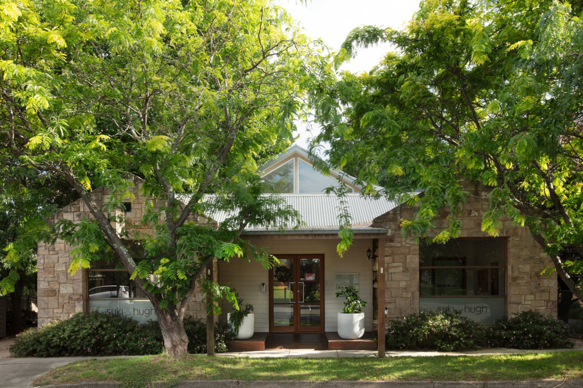 Stone shop frontage surrounded by trees.