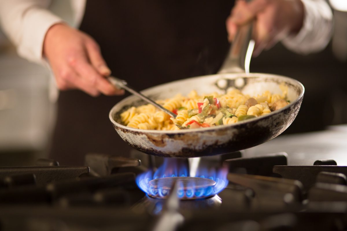 Person cooking over a gas stove