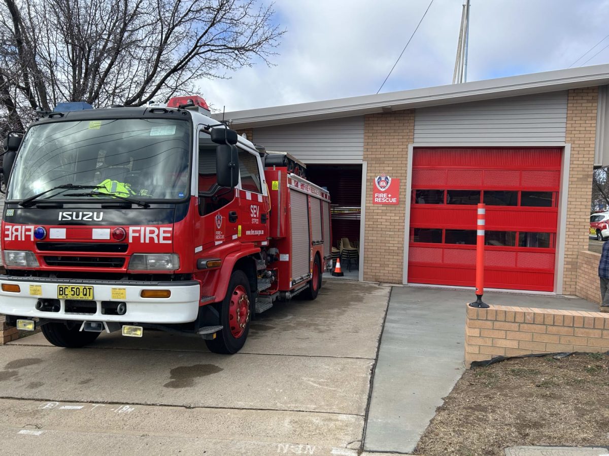 A fire truck parked in the driveway of a fire station