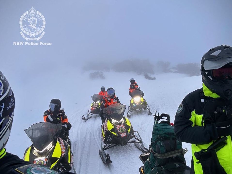 people on Snowcat vehicles in the mountains