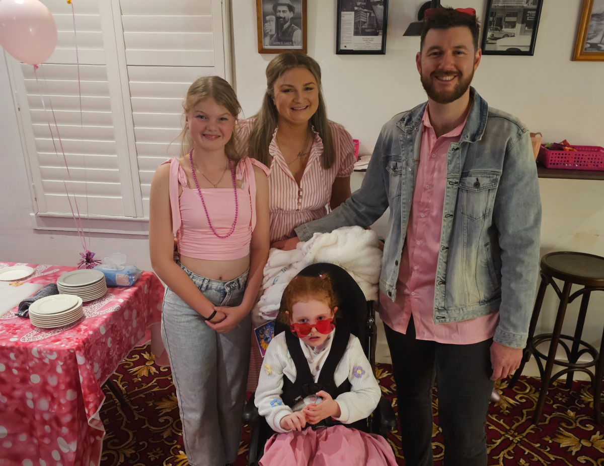 Family father around child in wheelchair.