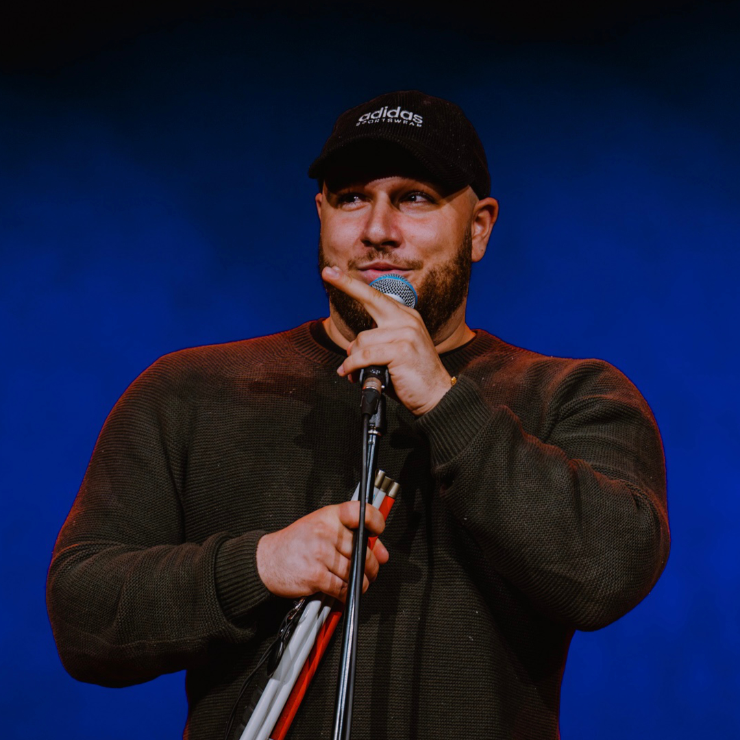 Man on stage with microphone.