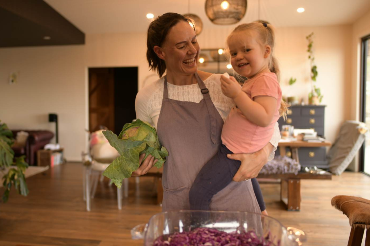Woman holding a toddler and a cabbage