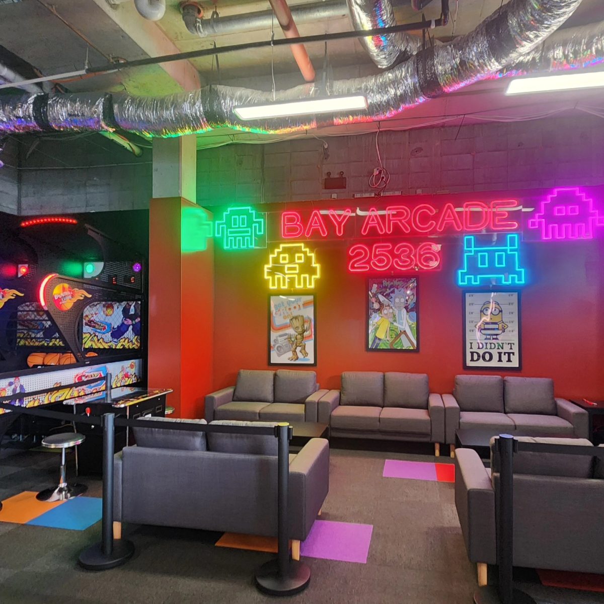 The inside of the business, showing neon signs and several grey couches