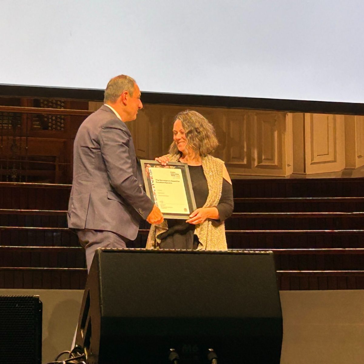 A man and a woman holding a framed award