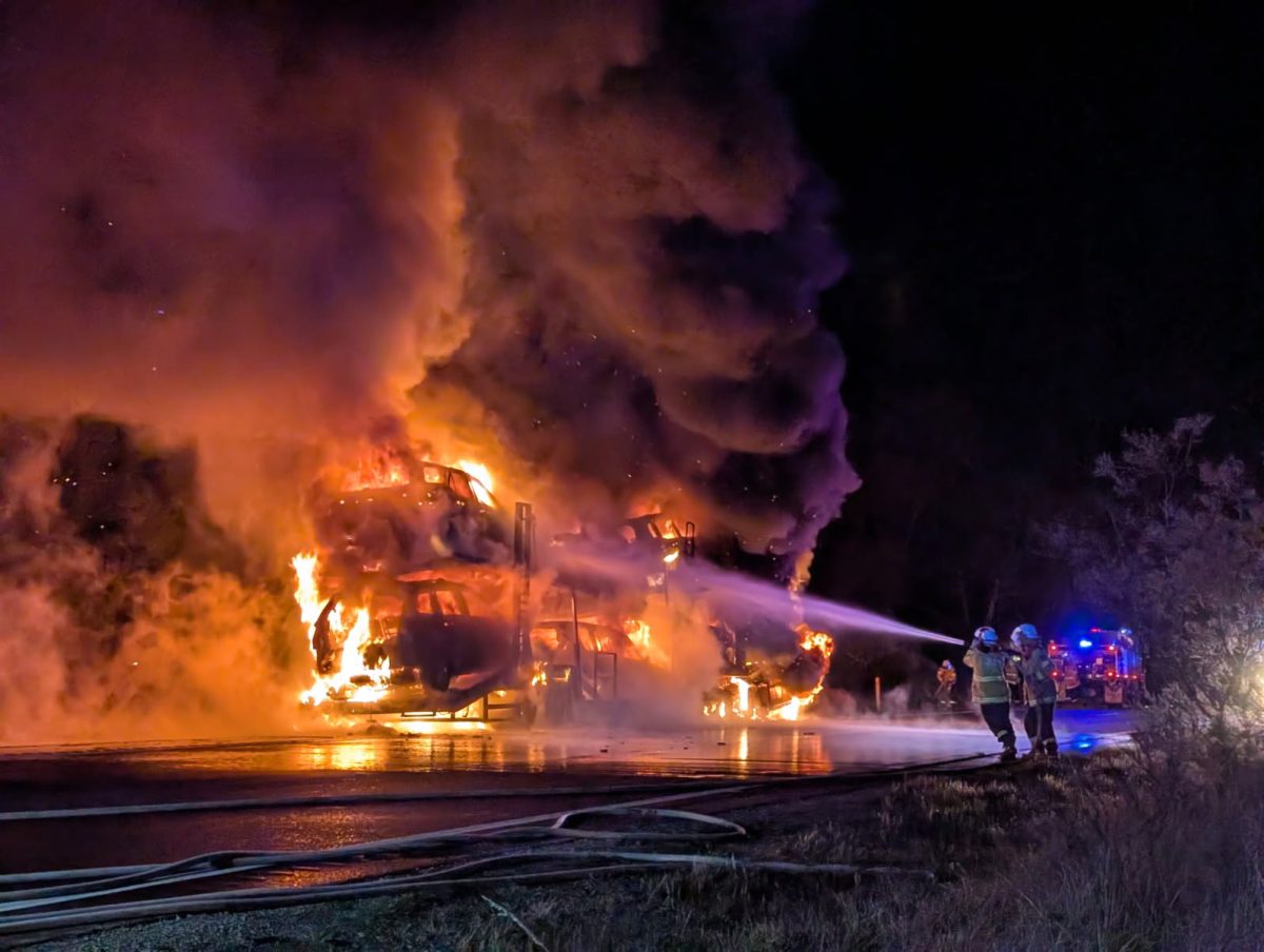Firefighters using hoses on burning cars in a truck