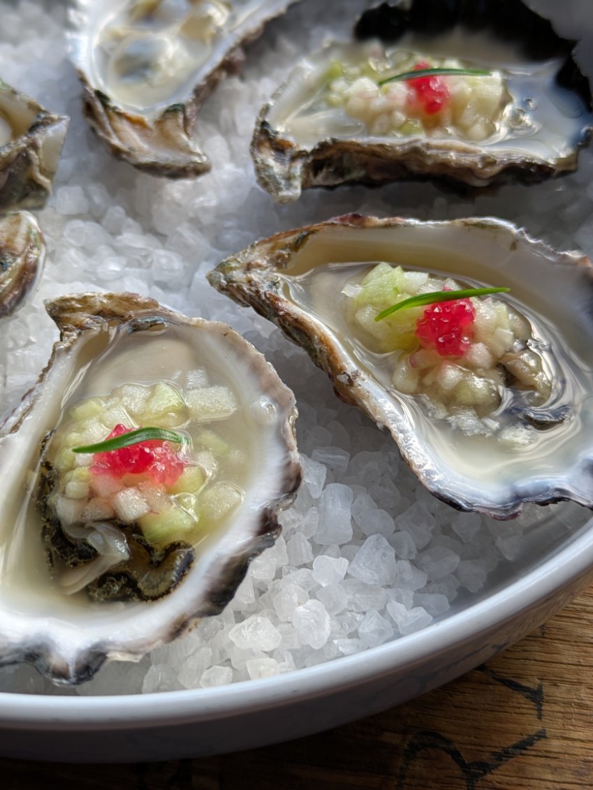 Oysters on rock salt with a fingerlime garnish.