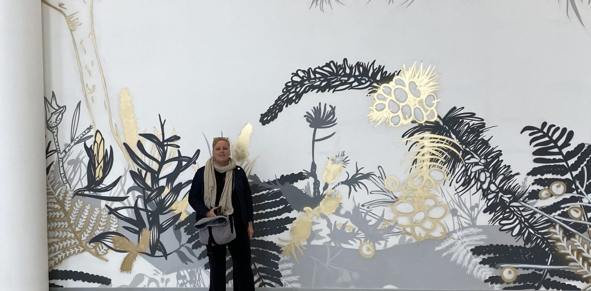 Dr Erica Seccombe in front of the 80-metre street mural she designed for Campbelltown Hospital in 2022.