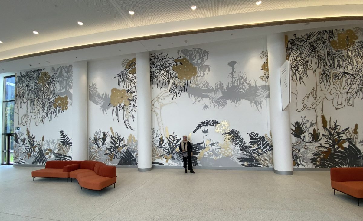 Dr Erica Seccombe in front of the 80-metre street mural she designed for Campbelltown Hospital in 2022.