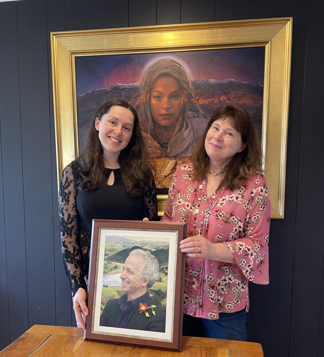 Two women holding photo of man