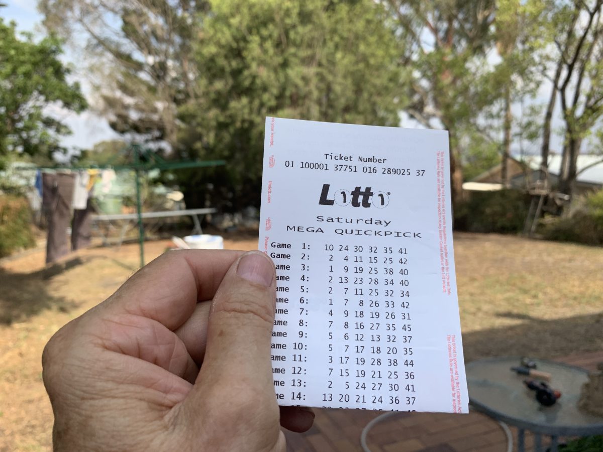 A hand holding a Lotto ticket