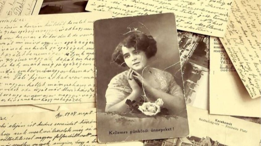 An old photo of a woman and a pile of old letters 