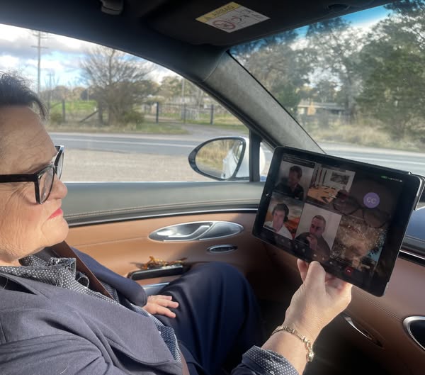 A woman looking at a computer screen in a car