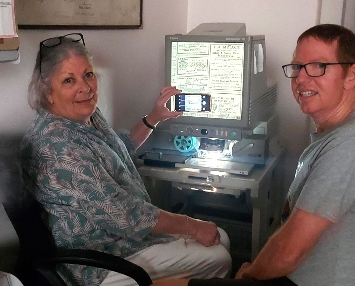 Man and woman look at microfilm newspapers