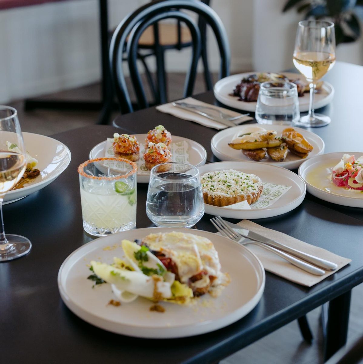 A restaurant table with dishes and drinks