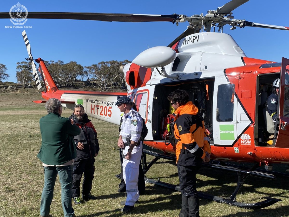group of people standing by a rescue helicopter